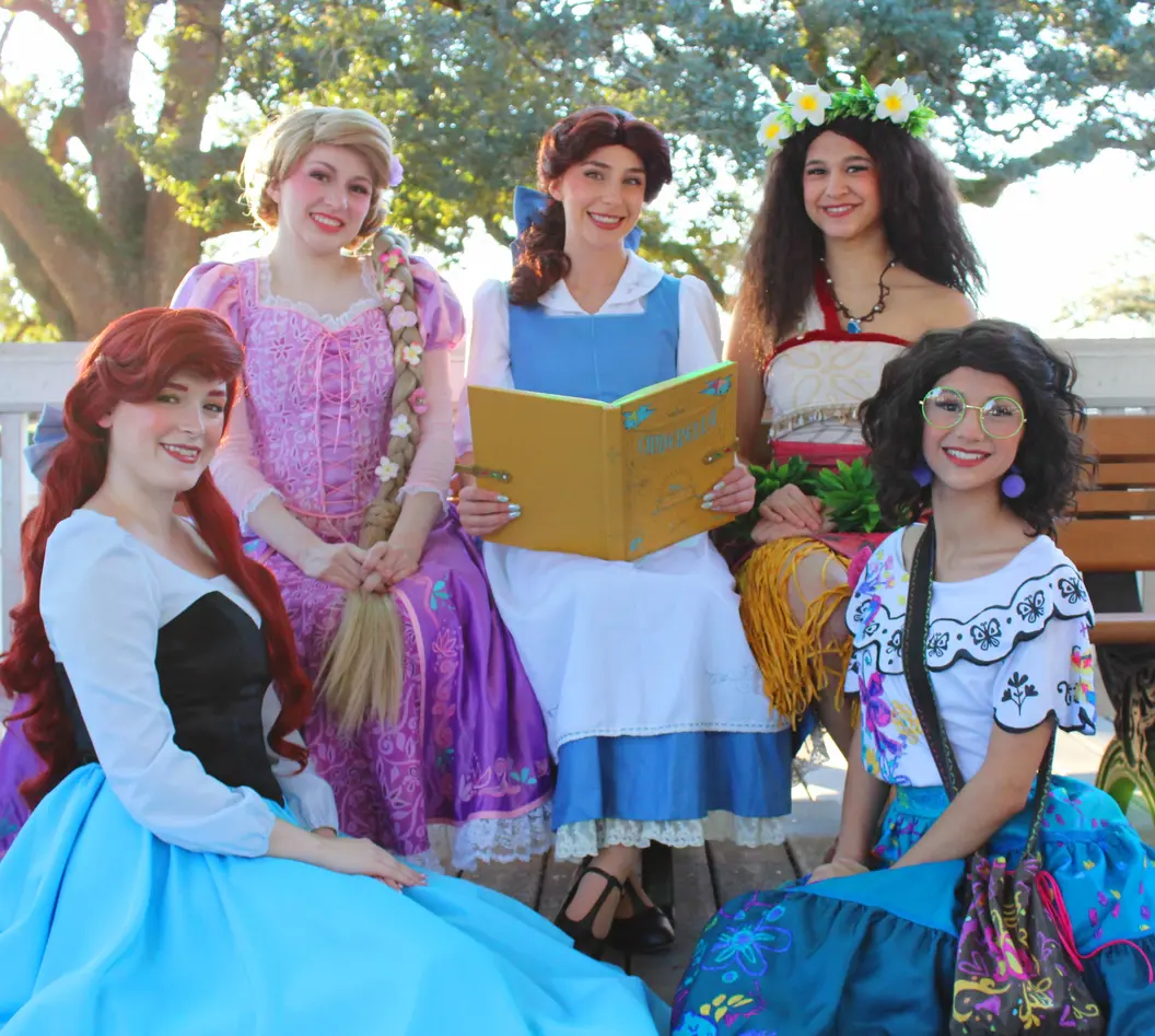A collection of princesses together on a bench listening to a story
